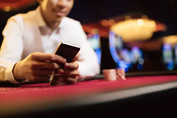 A young woman relaxing with her phone while dynamic casino elements float around her, illustrating the smooth mobile experience offered by the JILI998 app.