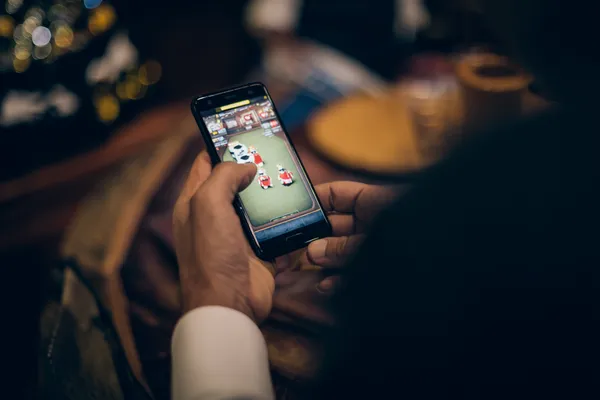 JILI998 Games — Discover modern slots and table adventures A man celebrating a winning moment on his laptop while gaming symbols float around him, capturing the excitement of JILI998 games.